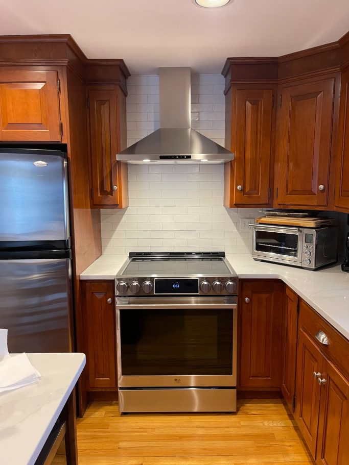 Modern kitchen featuring stainless steel appliances and wooden cabinetry.
